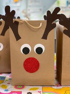 two brown paper bags with reindeer noses on them