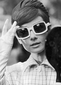 a woman wearing sunglasses and holding a tennis racket in front of her eyeglasses