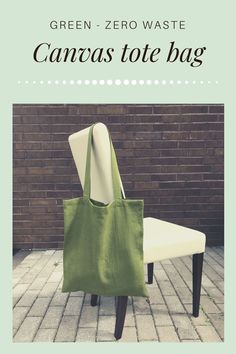 a green bag sitting on top of a white chair next to a brick wall with the words, green zero waste canvas tote bag