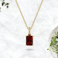 Description This stunning AAA quality Gold Garnet Pendant with the dazzling white diamond Dangling of I1-I2/G-H clarity & color is crafted in 14k solid gold. An Emerald Cut Octagon Garnet gemstone set with 4-prong settings surrounded with diamonds. Garnet is an official birthstone for the month of January and a symbol of balance, hope, and peace. The 7X5mm Octagon gemstone is flanked by 4 pcs of dazzling 1.10mm white diamonds together to create a Dangling frame. The gold chain shown in the pictu October Birthstone Necklace, Diamond Wedding Jewelry, Halo Necklace, Garnet Pendant, Garnet Jewelry, Gold Diamond Necklace, Birthstone Pendant, Amethyst Pendant, Garnet Gemstone