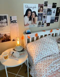 a bedroom with posters on the wall and a small table next to it, along with a bed