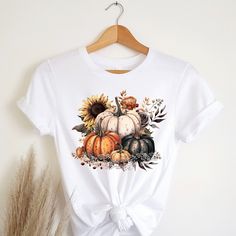 "Fall in love with these soft & comfy Bella Canvas t-shirts that are sure to be your new \"must have more\" shirts! Pumpkin t-shirt Autumn Vibes t-shirt Autumn shirt Fall Vibes tee Fall Colors t shirt Womens Fall tee Womens Fall Harvest tee Harvest Vibes shirt Festive tee Gift Womens shirt Gift for women Womens gift Recommendations: *For a standard fit, stick with your typical size *For an oversized fit, size up *For a fitted shirt, size down. *Shirts are longer. Great for knots, Tucks, or nice coverage with leggings. *Unisex Cut. works great for Everyone! Women sizes: Small: 2-4 | Medium: 6-8 | Large: 10-12 | XL: 14-16 | 2XL: 18-20 | 3XL: 22-24 | 4XL: 26-28 Men sizes: Select your standard size. Details: *Soft, Breathable, & very comfy Bella + Canvas *Pre-shrunk fabric *Solid Colors: 100% White Graphic Print T-shirt For Fall, White Short Sleeve Shirt For Fall, Fall Sublimation Print Relaxed T-shirt, Fall Sublimation Print Relaxed Fit T-shirt, Fall T-shirt With Sublimation Print In Relaxed Fit, White Graphic Tee For Fall, Fall Relaxed Fit T-shirt With Sublimation Print, White Sublimation Print Top For Fall, Graphic Tee With Sublimation Print For Fall