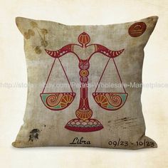 a decorative pillow with an image of a scales on the front and side, which reads libra