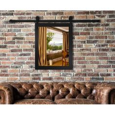 a living room with a couch and brick wall in the background is an open window