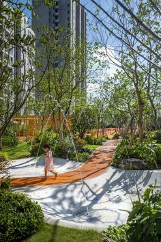 a woman sitting on a swing in the middle of a park with trees and grass