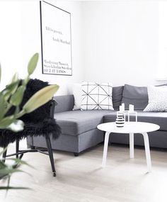 a living room with a gray couch and white coffee table in front of a large window