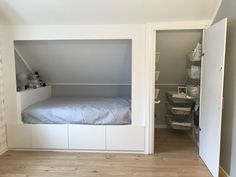 an empty room with a bed in the corner and shelves on the wall behind it