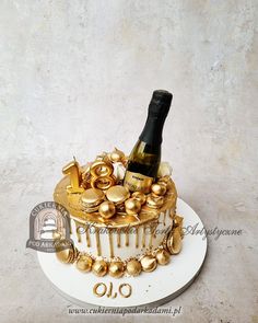 a cake decorated with gold decorations and a bottle of wine