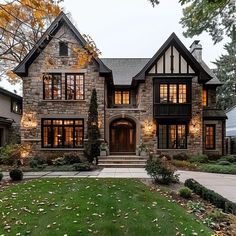 a large house with lots of windows and lights on it's front lawn area