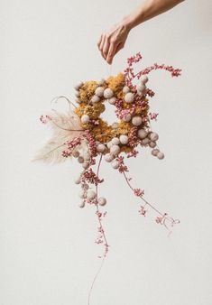 a person holding a bunch of dried flowers