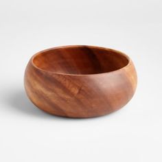 a wooden bowl sitting on top of a white table