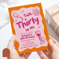 two hands holding up a pink and orange birthday card with the words talk thirty to me on it