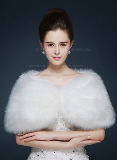 a woman in a white dress with a fur stole on her shoulders and arms crossed