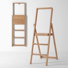 a wooden folding chair next to a mirror