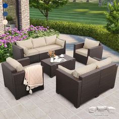 an outdoor patio furniture set is shown in front of some flowers and bushes with purple flowers