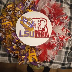 a close up of a wreath with the word lsu in red, yellow and purple