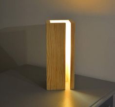 a wooden lamp sitting on top of a counter next to a wall mounted microwave oven