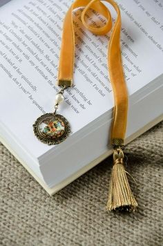 an open book with a tassel on it and a yellow ribbon around the neck