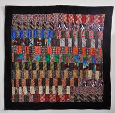 a quilted wall hanging with many different colors and patterns on it's sides