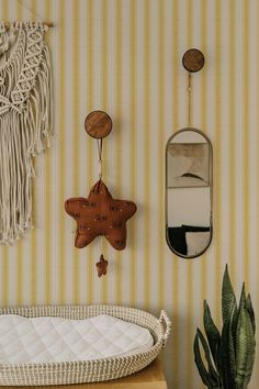 a baby crib in front of a striped wallpapered room with hanging decorations