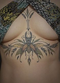 a woman's stomach with an insect tattoo on it