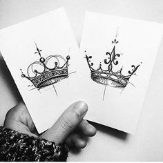 two cards with crowns drawn on them are being held up by someone's hand