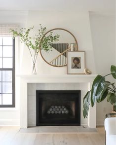 a living room with a fireplace and pictures on the wall