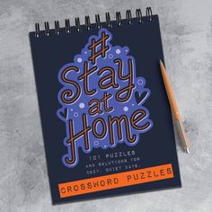 a spiral notebook with the words stay at home on it next to a pen and pencil