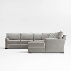 a large sectional couch with pillows on the back and footrests, in front of a white background