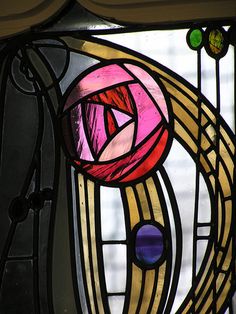 a close up of a stained glass window with an abstract design on the bottom half