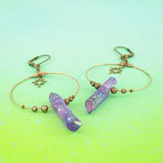 These iridescent purple quartz crystal earrings are the perfect celestial gift idea. Each antique copper hoop earring has a genuine stone hanging beneath an art deco starburst charm and surrounded by dainty copper beads. These earrings are a bold conversation starter. They are a bit heavy due to the fact that these are real quartz crystals, but the ultra light hoop and charms help offset the weight. A gorgeous oddity jewelry set. -Genuine iridescent purple quartz crystals -Art deco starburst cha Iridescent Metal Drop Earrings, Celestial Metal Hoop Earrings Gift, Mystical Purple Nickel-free Jewelry, Mystical Nickel-free Purple Jewelry, Purple Festival Jewelry With Ear Wire, Mystical Copper Jewelry For Gifts, Mystical Copper Jewelry For Gift, Handmade Iridescent Metal Jewelry, Spiritual Copper Drop Earrings