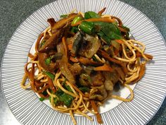 a white plate topped with noodles and vegetables