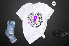 Show your support for epilepsy awareness with this stylish crewneck sweatshirt. Perfect as a gift for a loved one or for yourself, this motivational tee features a purple ribbon design to raise awareness for epilepsy. Whether you're an epilepsy mom or simply want to show your support, this epilepsy shirt is a great way to spread awareness and positivity. Made with high-quality materials, this crewneck sweatshirt is comfortable to wear and perfect for everyday use. The purple ribbon design is a subtle yet powerful way to show your support for those affected by epilepsy. This awareness shirt is not only a great addition to your wardrobe, but also a meaningful way to make a difference. Get this motivational gift for her and make a statement while supporting a great cause. Whether you're looki Epileptic Seizures Quotes, Non Epileptic Seizures, Epileptic Quotes, Psychogenic Non-epileptic Seizures, Awareness Shirt, Purple Ribbon, Ribbon Design, The Purple, Mom Shirt