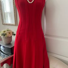 Add Elegance And Style To Your Wardrobe With This Beautiful Brooks Brothers Lanificio Campore Red Dress. This Dress Features A Flattering Fit And Flare Style With A Knee-Length Hemline, Perfect For Any Party Or Cocktail Occasion. The Dress Is Made Of 100% Wool Fabric With A Solid Pattern In Red Color, And It Comes In Size 2 With A Scoop Neckline And Sleeveless Design. The Dress Has A Drop Waist Feature With Pleated And Invert Pleated Accents, Giving It A Unique And Classy Look. It Has A Zip Clos Elegant Red Midi Dress For Gala, Elegant Red A-line Dress, Elegant Red Fit And Flare Midi Dress, Elegant Red Fit And Flare Dress, Elegant Red Midi Dress For Wedding, Red Midi Dress With Fitted Bodice For Formal Occasions, Classic Red Midi Dress For Formal Occasions, Formal Red Midi Dress With Fitted Bodice, Red Fit And Flare Formal Dress