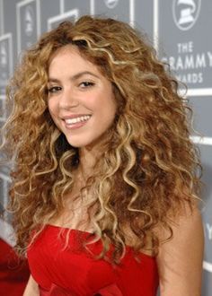 a woman with long curly hair wearing a red dress