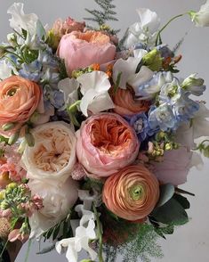 a bunch of flowers that are sitting in a vase on a table with white and pink flowers