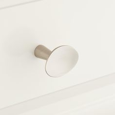 a close up of a door handle on a white cabinet