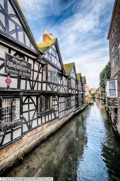 a river running between two buildings next to each other in the middle of a town