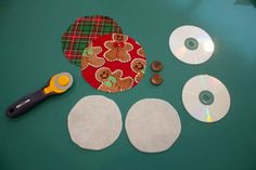 the supplies needed to make christmas cookies are laid out on a green table with cd's and buttons