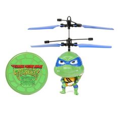 a toy with a green turtle on it next to a plastic flying disc that says teenage mutant