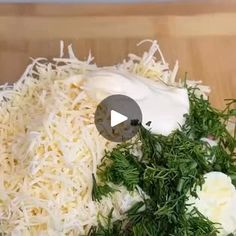 a wooden cutting board topped with cheese and herbs