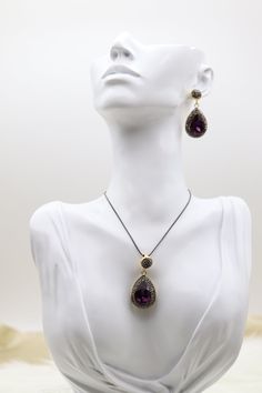 This set features a necklace and earrings, each adorned with a dark amethyst druzy in a teardrop shape, offering a rich, deep purple hue that catches the light beautifully. The natural texture of the druzy is highlighted by minimalist settings, enhancing the stone's raw, organic charm and making it a striking choice for any occasion. Length: 28” - Adjustable Necklace Teardrop Pendant: 42.0 mm (length); 19.3 mm (width) Closure: Adjustable Material: Brass with 18K Gold Plating and Rhodium Coating Teardrop Amethyst Jewelry For Party, Elegant Handmade Teardrop Jewelry Sets, Dark Amethyst, Teardrop Pendant, Necklace And Earring Set, Amethyst Necklace, Purple Hues, Adjustable Necklace, Necklace And Earrings