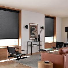 a living room filled with furniture and windows covered in black roller shade shades on the windows