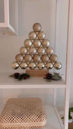 a christmas tree made out of ornaments on a shelf in a room with white walls