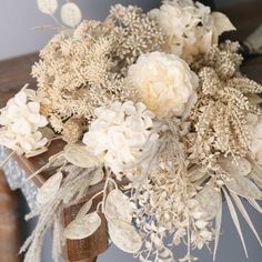 a vase filled with white flowers on top of a wooden table