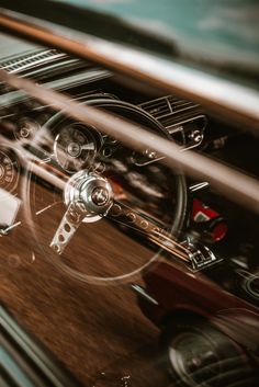 the interior of an old car with wood and metal trims, including steering wheel