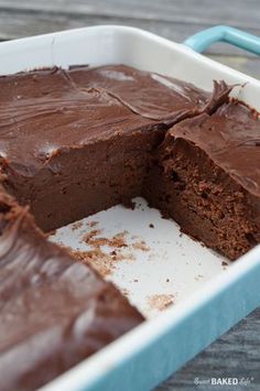 a chocolate cake in a pan with one piece cut out and ready to be eaten