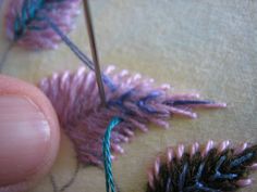 someone is stitching something with yarn on the table