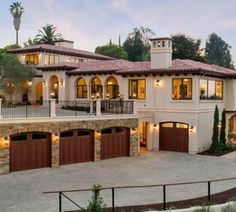 a large house with two garages on the top floor and an attached balcony above it