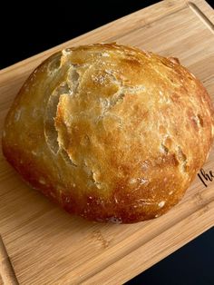 a loaf of bread sitting on top of a wooden cutting board